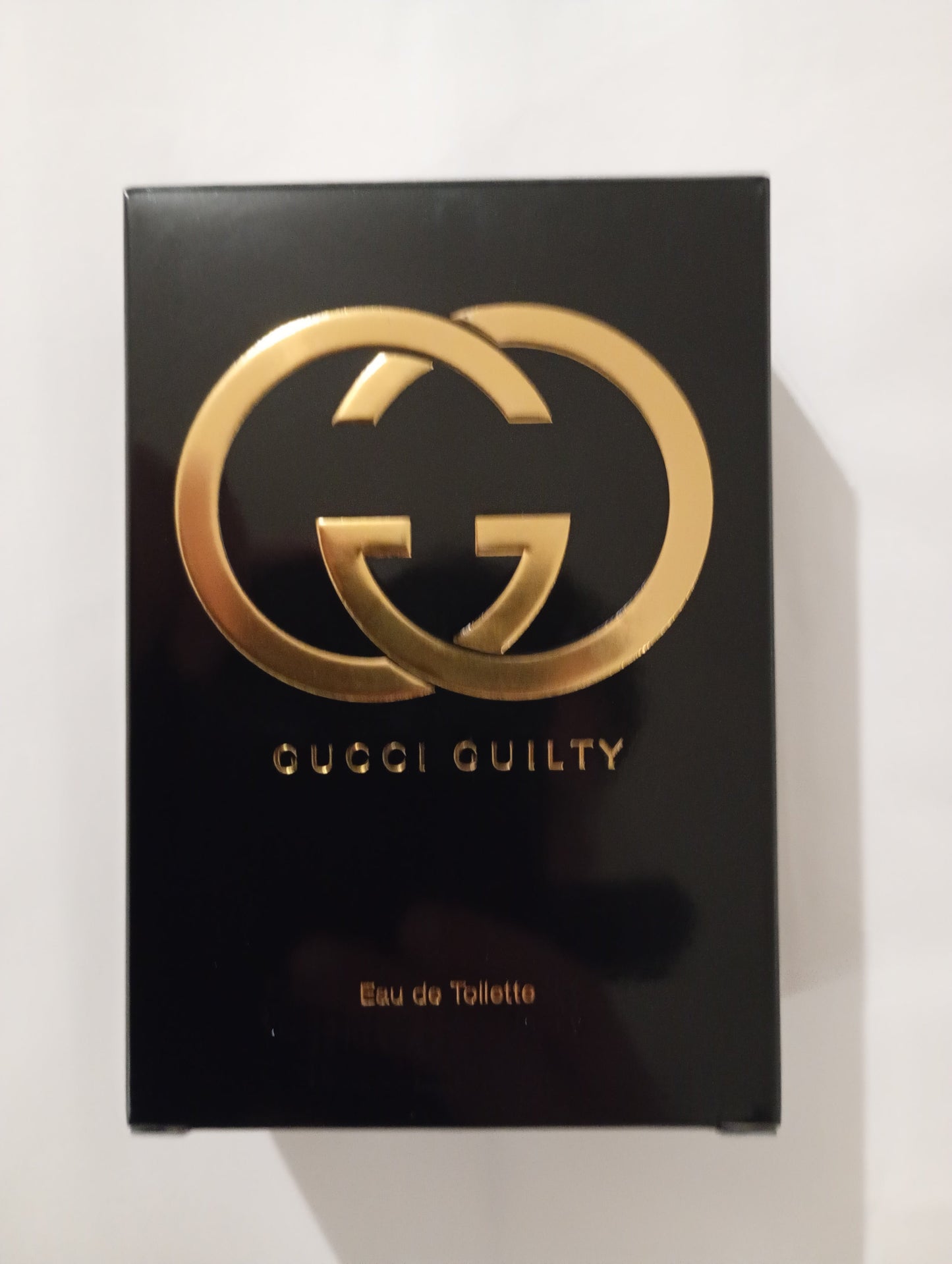 Gucci Guilty EdT 75 ml pullo edestä, metallinen ruusukultainen korkki ja Guccin G-logo